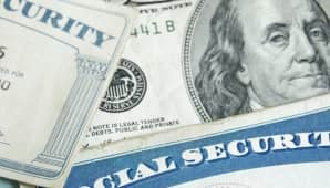 Social Security Card laying over 100 dollar bill.