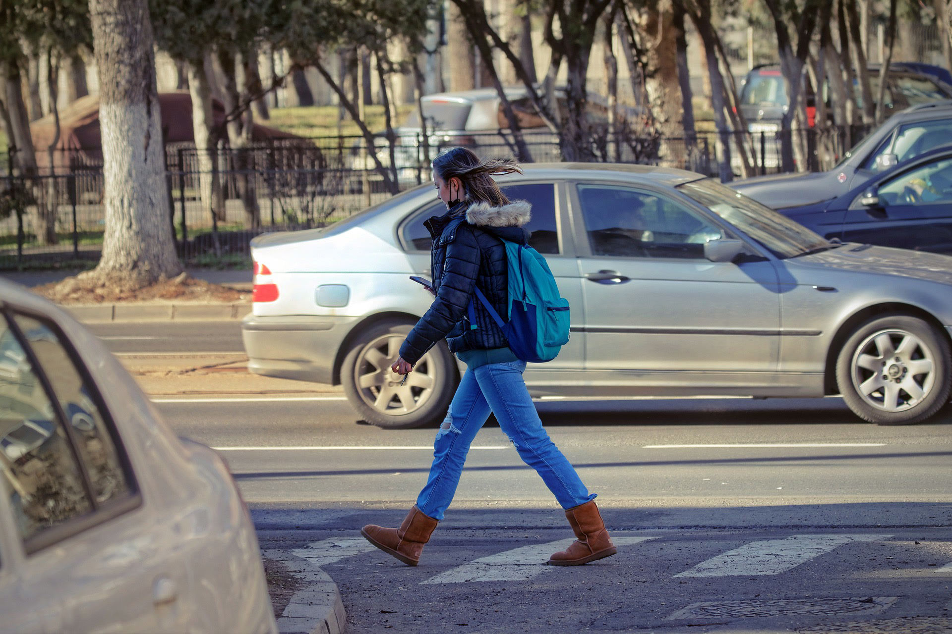 A woman uses the crosswalk while practicing pedestrian safety.