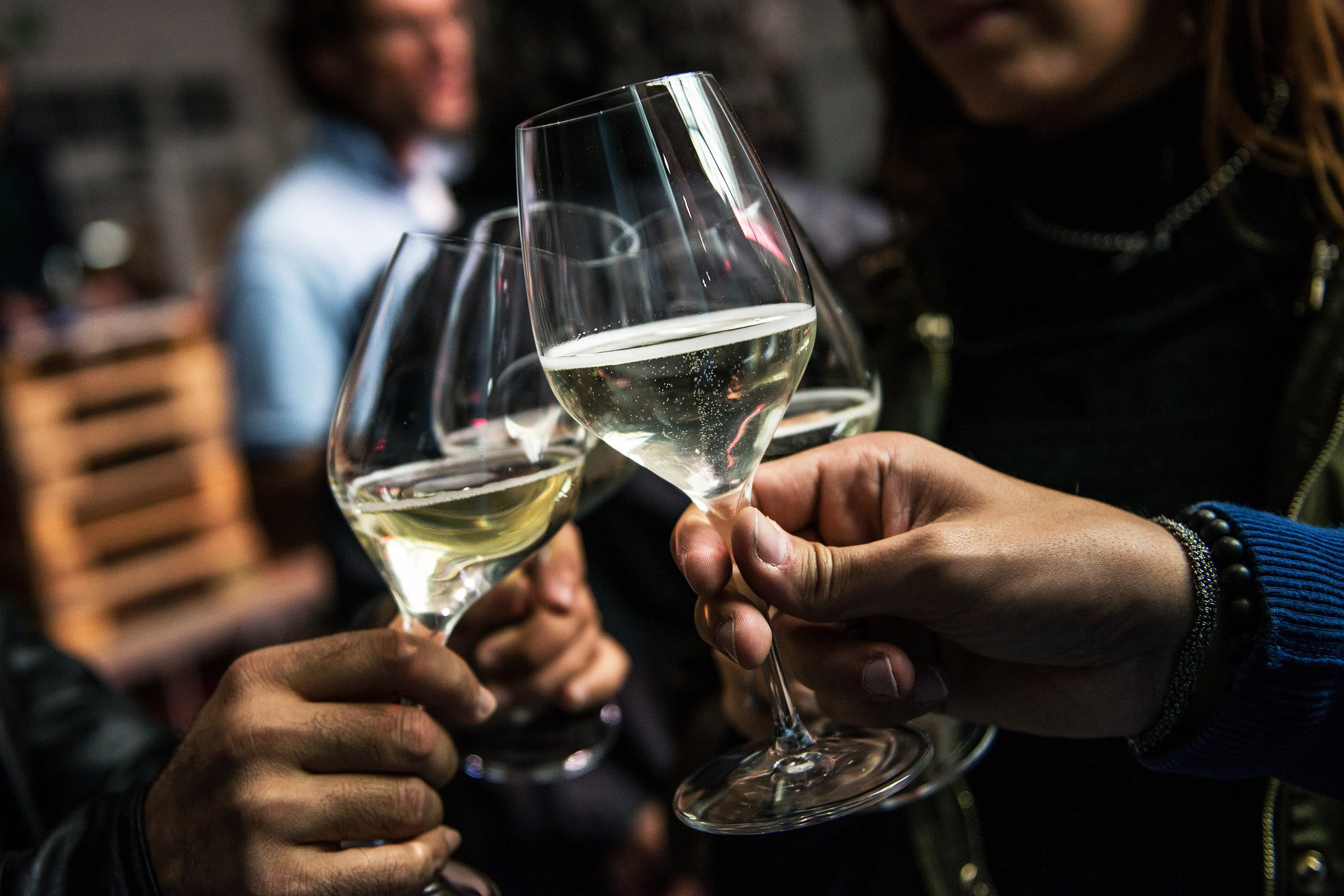 Adults clink their wine glasses at a holiday party where they have designated rides home.