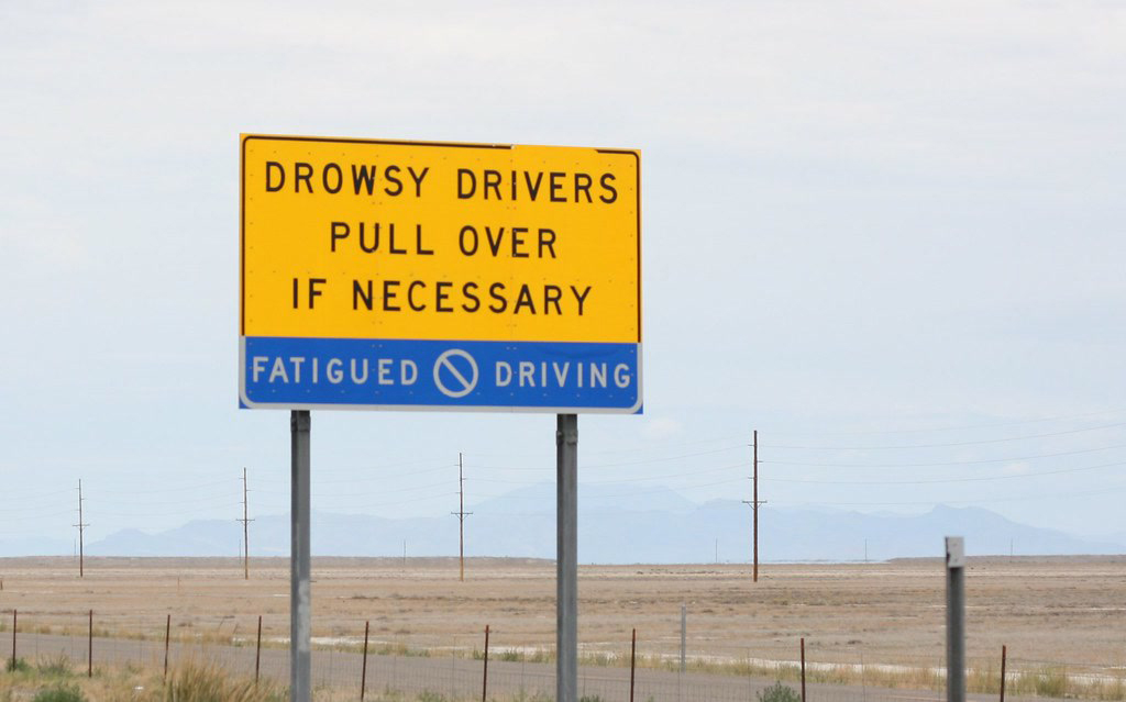 Traffic sign reads "Drowsy Drivers pull over if necessary."