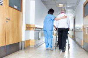 nursing home nurse assisting resident with walker