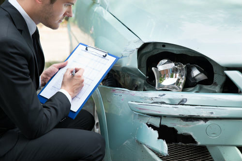 insurance adjuster taking notes at car accident