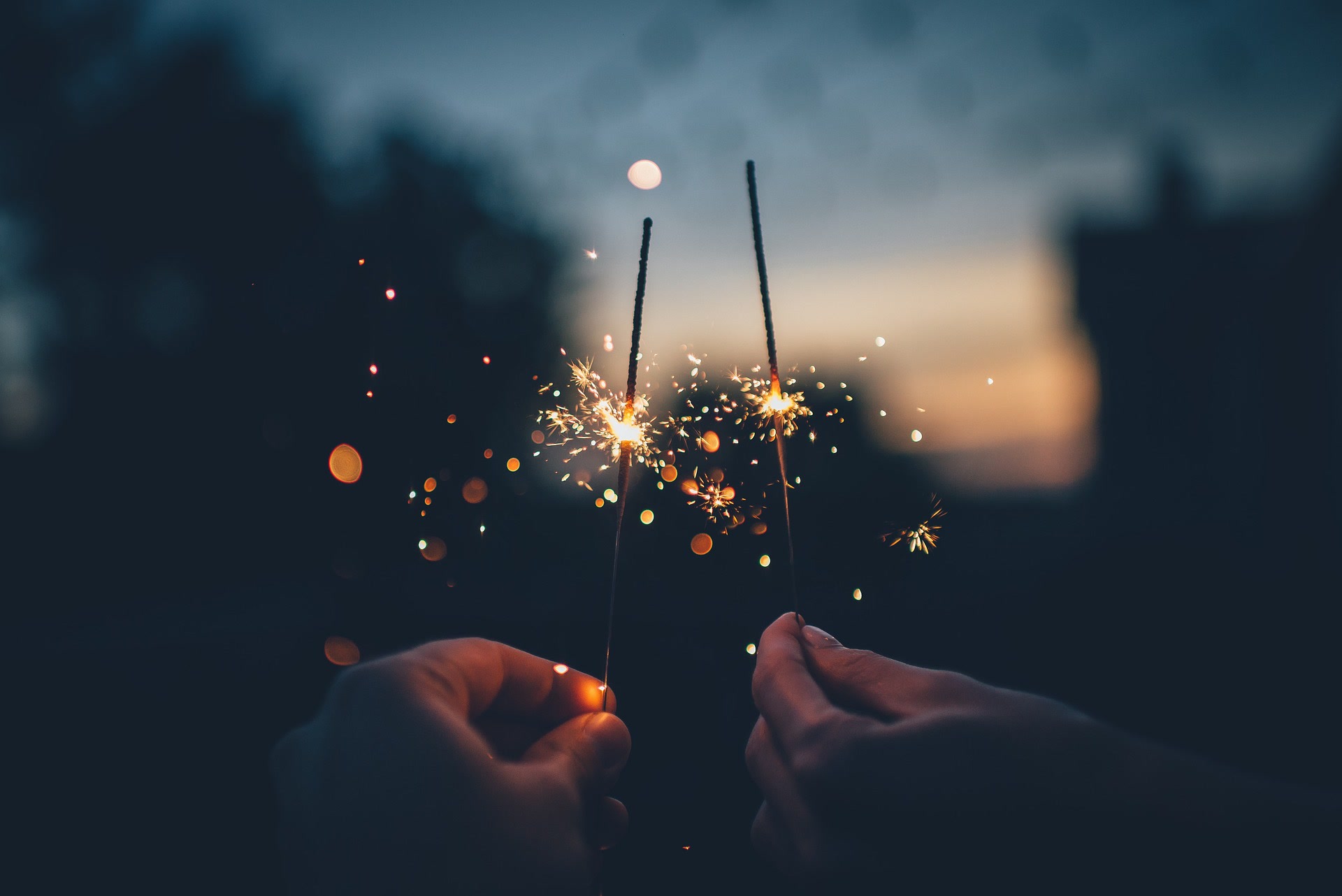 Two fourth of July sparklers in front of a sunset.