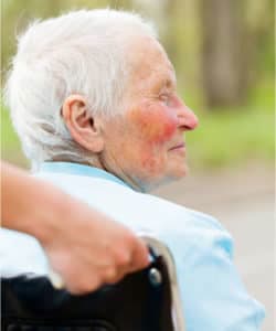 elderly patient being pushed in a wheelchair