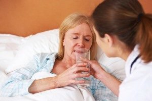 nurse giving nursing home resident water