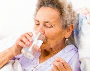 nursing home patient taking medication with water